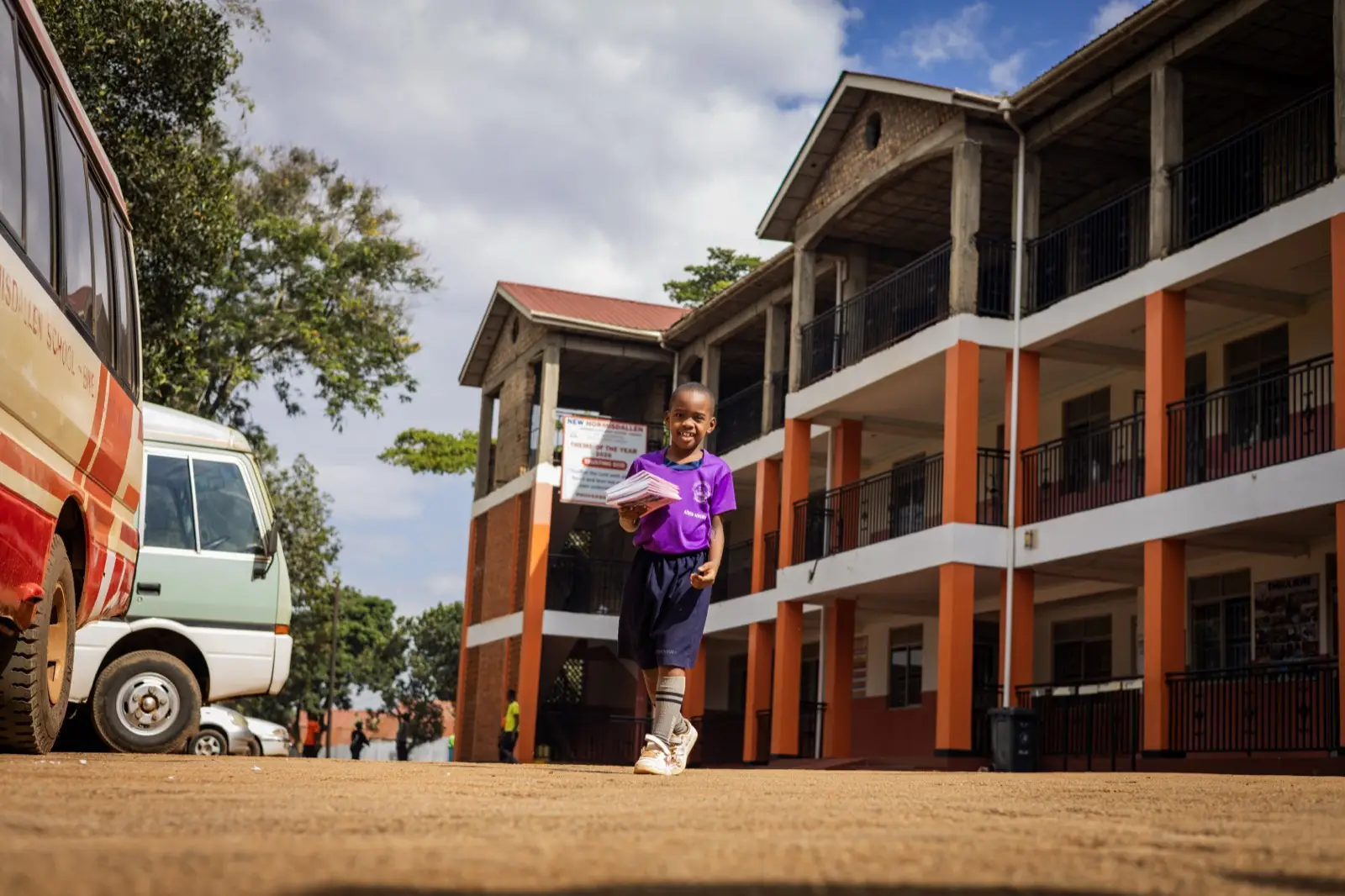 A learner walking past the main classroom block