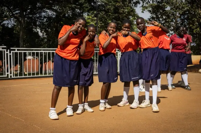 Learners in orange uniform standing together